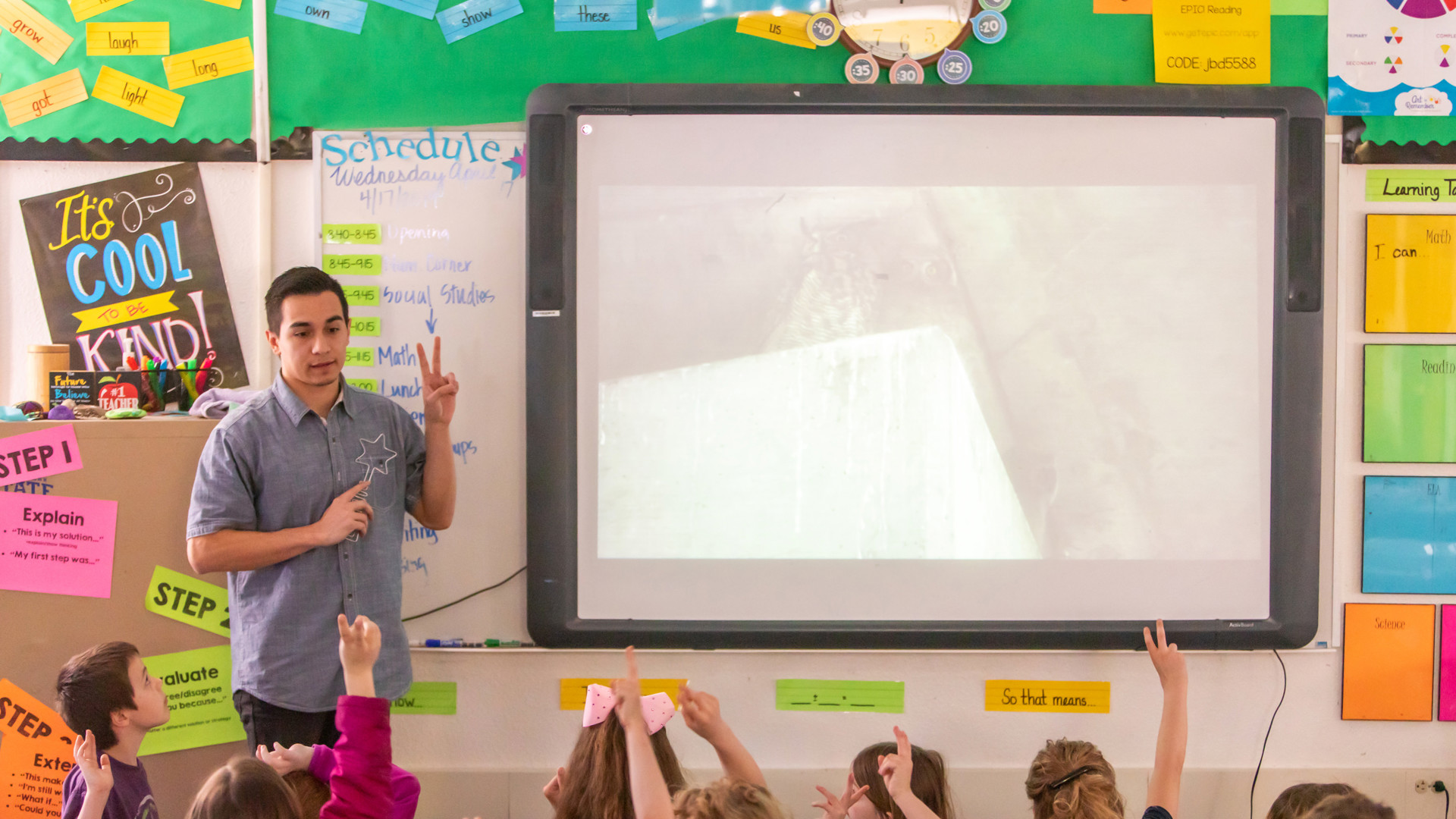 Male teaching teaching children in a classroom